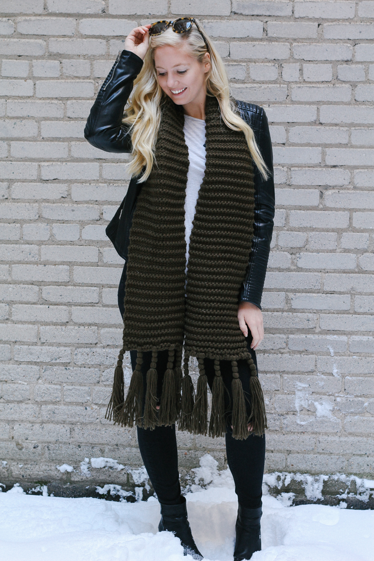 A faux leather jacket, booties, and an oversized scarf for a winter date night outfit